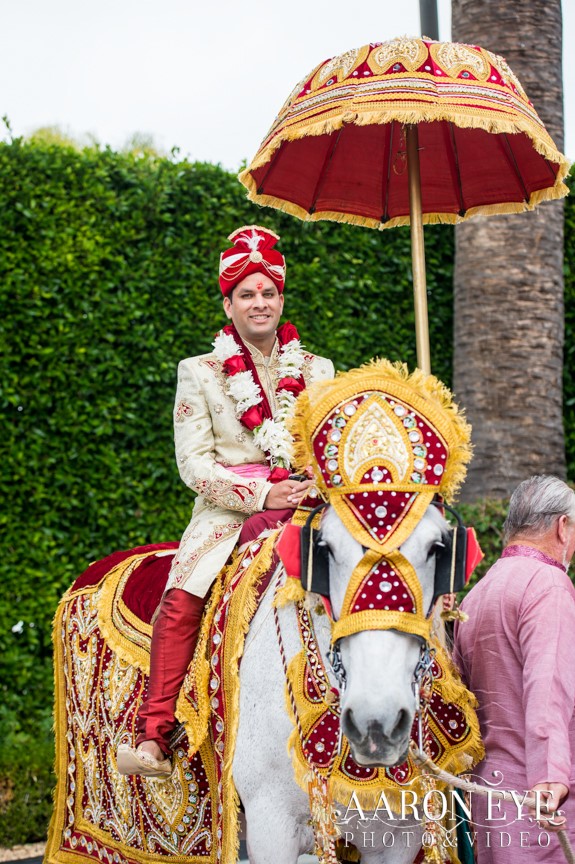 Groom arriving at wedding on horsebak