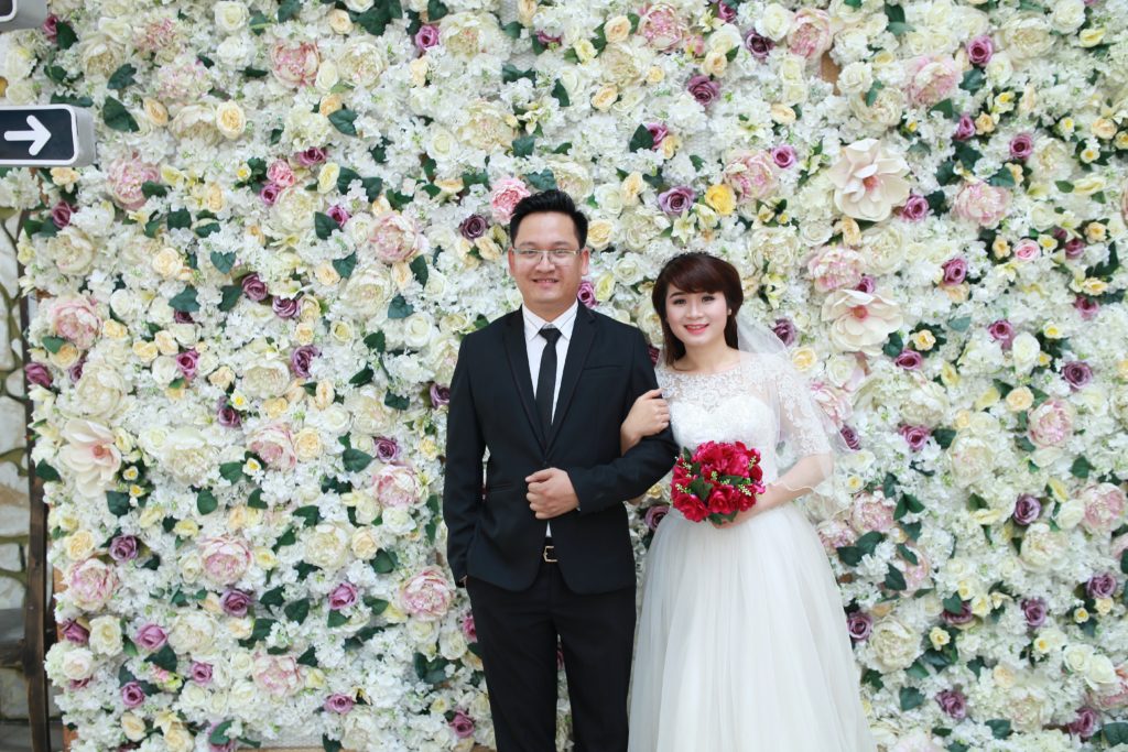 wall of flowers bride & groom